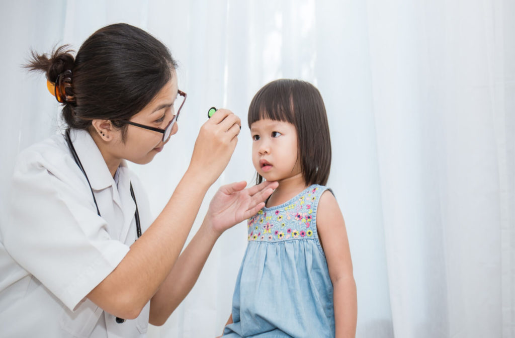 a toddler has an eye exam at the optometrist to determine if she needs glasses