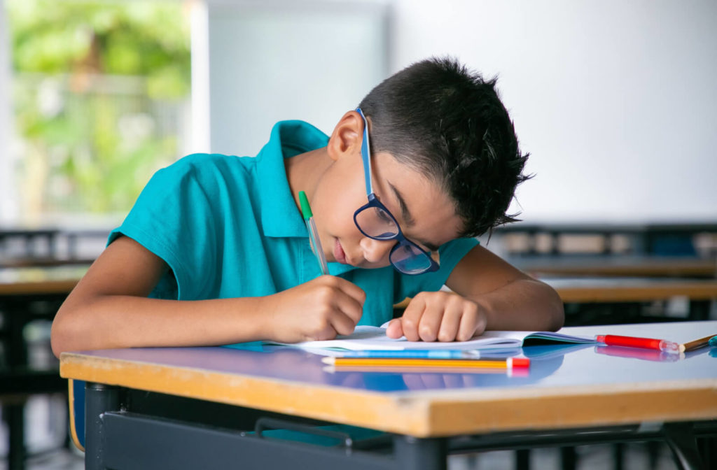 A boy wearing myopia control lenses at school to help slow myopic progression