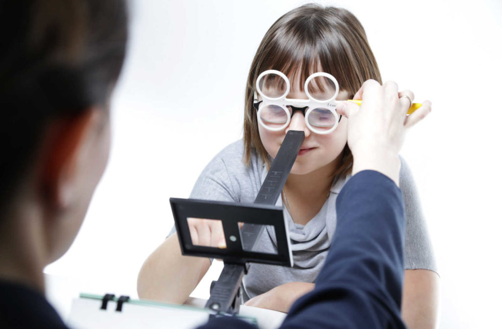 A young girl and her optometrist during a vision therapy appointment to help treat lazy eye