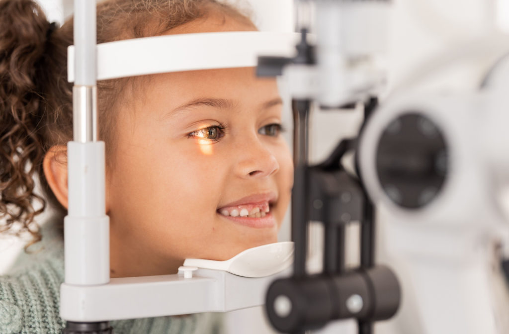 A young girl having her eyes examined at the eye doctor to check for common visual issues such as myopia or strabismus.