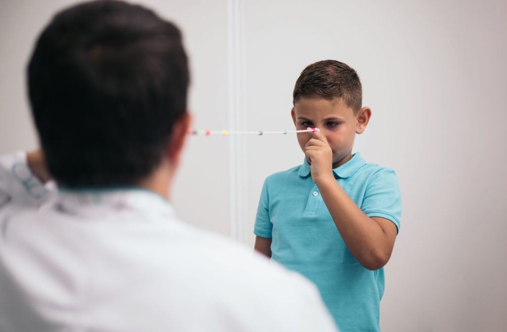 A young athlete using a Brock String during vision therapy with his eye doctor to improve his eye coordination.