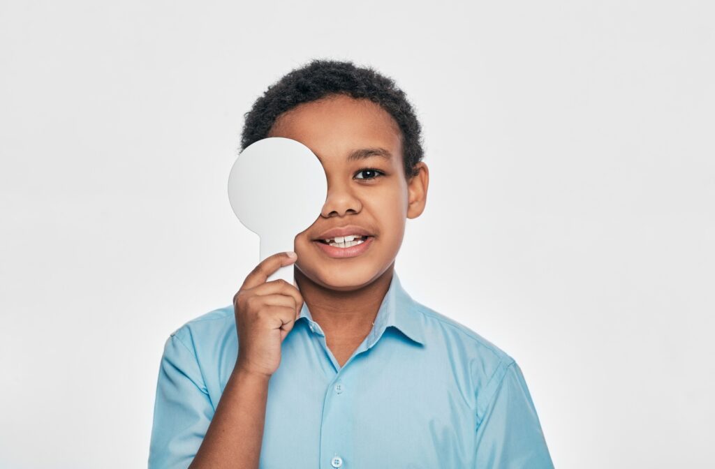 A child holding an eye cover during a binocular vision test.