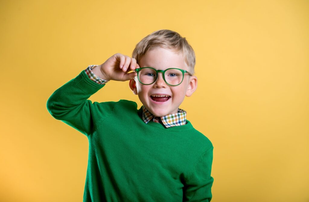 A cheerful child smiles brightly while wearing their myopia control eyeglasses.