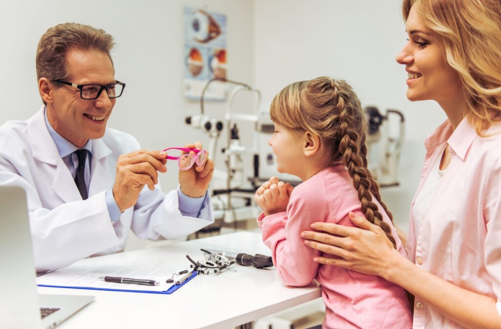 An eye doctor explains the perks of myopia control eyeglasses to a young patient and their parent.