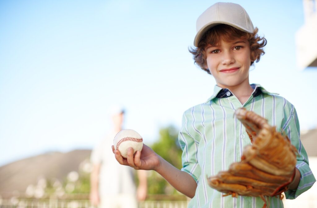 A child playing with a baseball glove and baseball