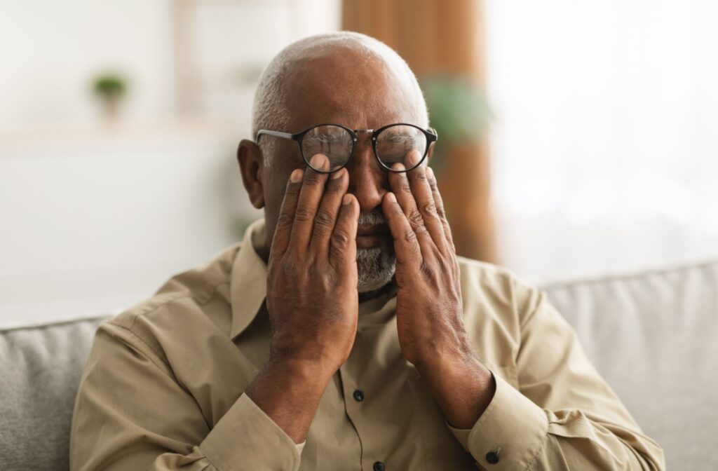A person pushing their glasses up to rub their irritated eyes